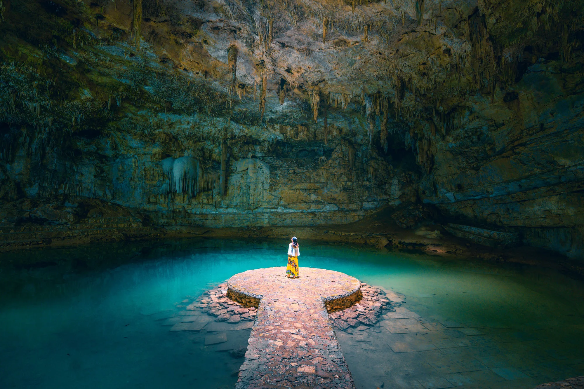 Woman standing alone in a cenote in Mexico
